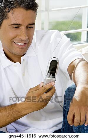 Close-up of a mid adult man looking at a mobile phone View Large Photo Image Stock Photograph - Close-up of a mid adult man looking at a mobile phone. Fotosearch