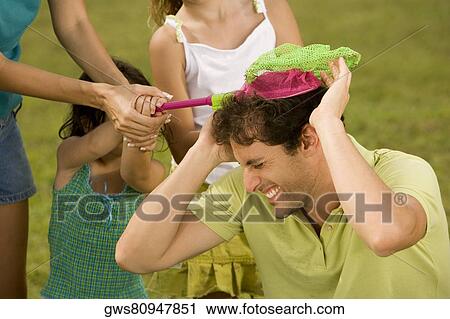 Close-up of a mid adult man playing with his family View Large Photo Image Stock Image - Close-up of a mid adult man playing with his family. Fotosearch