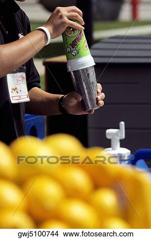 Picture - Close-up of a person holding a glass of juice. Fotosearch
