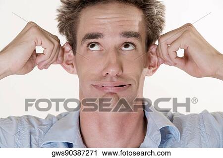 Close-up of a young man holding his ears View Large Photo Image Stock Image - Close-up of a young man holding his ears. Fotosearch