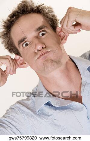 Close-up of a young man pulling his ears View Large Photo Image Stock Image - Close-up of a young man pulling his ears. Fotosearch