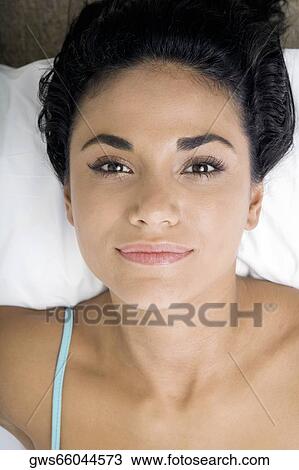 Close-up of a young woman lying on a bed View Large Photo Image Stock Image - Close-up of a young woman lying on a bed. Fotosearch