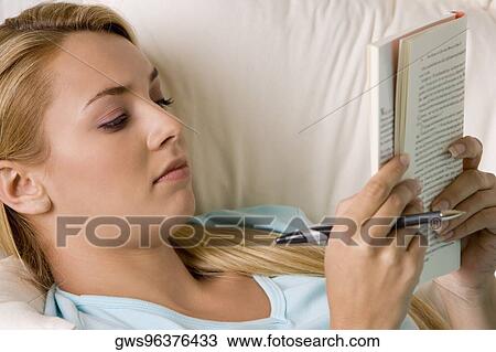 Stock Image - Close-up of a young woman reading a book. Fotosearch