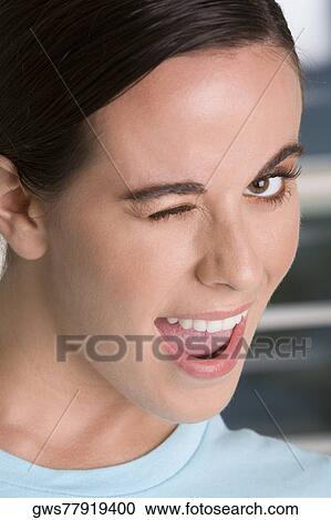 Close-up of a young woman winking View Large Photo Image Stock Image - Close-up of a young woman winking. Fotosearch