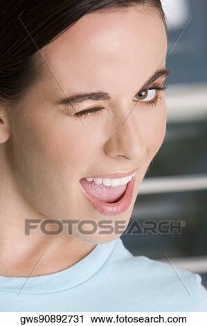 Close-up of a young woman winking View Large Photo Image Stock Image - Close-up of a young woman winking. Fotosearch