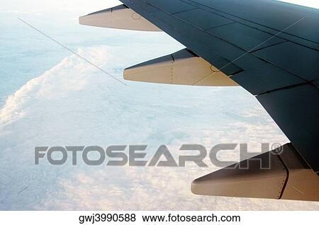 Close-up of an airplane wing in flight View Large Photo Image Stock Photo - Close-up of an airplane wing in flight. Fotosearch