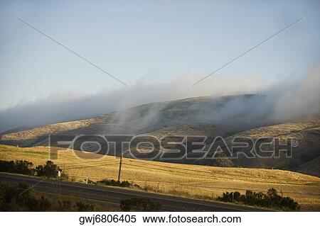 Clouds rolling over a hill range View Large Photo Image Stock Photography - Clouds rolling over a hill range. Fotosearch