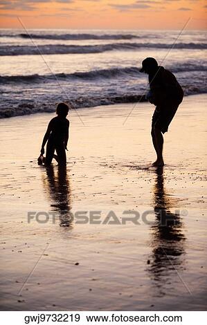 Father and his daughter playing in the water at the beach View Large Photo Image Stock Photo - Father and his daughter playing in the water at the beach. Fotosearch