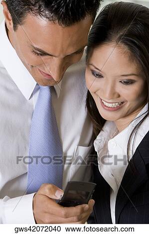 High angle view of a businessman and a businesswoman operating a mobile phone View Large Photo Image Stock Image - High angle view of a businessman and a businesswoman operating a mobile phone. Fotosearch