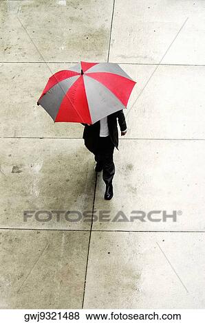 High angle view of a businessman walking with an umbrella View Large Photo Image Stock Photo - High angle view of a businessman walking with an umbrella. Fotosearch