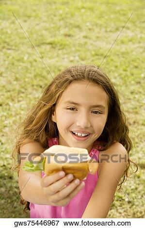 High angle view of a girl holding a burger View Large Photo Image Stock Photo - High angle view of a girl holding a burger. Fotosearch