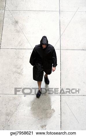 High angle view of a man walking in a raincoat View Large Photo Image Stock Image - High angle view of a man walking in a raincoat. Fotosearch