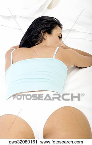High angle view of a young woman lying on a bed View Large Photo Image Stock Image - High angle view of a young woman lying on a bed. Fotosearch