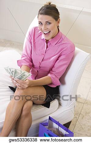 High angle view of a young woman holding American currency View Large Photo Image Stock Photo - High angle view of a young woman holding American currency. Fotosearch