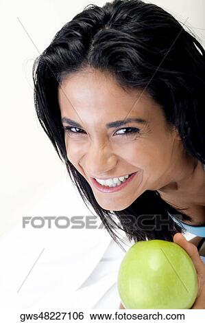 High angle view of a young woman holding a green apple View Large Photo Image Stock Photograph - High angle view of a young woman holding a green apple. Fotosearch