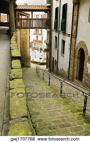 Stock Photo - High angle view of an empty alleyway leading to the street, Spain. Fotosearch