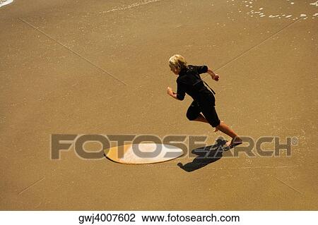Stock Image - High angle view of two boogie boarder's on the beach. Fotosearch