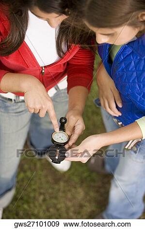 High angle view of two teenage girls holding an antique compass View Large Photo Image Stock Photo - High angle view of two teenage girls holding an antique compass. Fotosearch