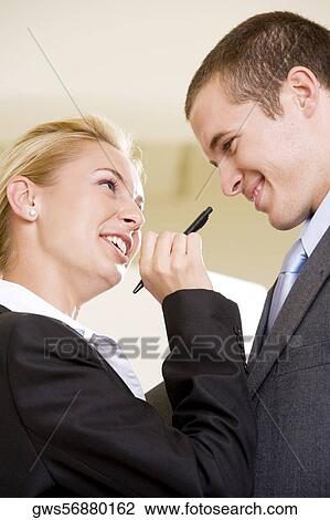 Low angle view of a businesswoman holding a pen in front of a businessman View Large Photo Image Stock Image - Low angle view of a businesswoman holding a pen in front of a businessman. Fotosearch