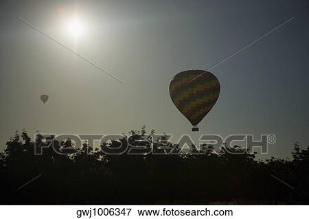 Low angle view of a hot air balloon flying in the sky View Large Photo Image Stock Photo - Low angle view of a hot air balloon flying in the sky. Fotosearch