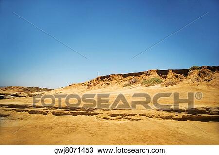 Stock Image - Low angle view of a man standing on the dunes, Coronado Reefs, San Diego, California, USA. Fotosearch