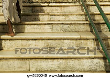 Stock Photography - Low angle view of a man walking up stairs, Pushkar, Rajasthan, India. Fotosearch