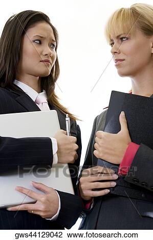 Low angle view of two businesswomen standing face to face View Large Photo Image Stock Image - Low angle view of two businesswomen standing face to face. Fotosearch
