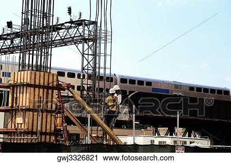 Low angle view of two men working on a platform near the railroad tracks View Large Photo Image Stock Image - Low angle view of two men working on a platform near the railroad tracks. Fotosearch