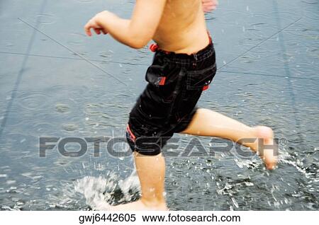 Low section view of a boy playing in water View Large Photo Image Stock Photography - Low section view of a boy playing in water. Fotosearch