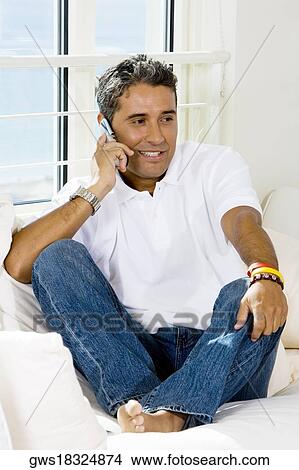 Mid adult man talking on a mobile phone View Large Photo Image Picture - Mid adult man talking on a mobile phone. Fotosearch