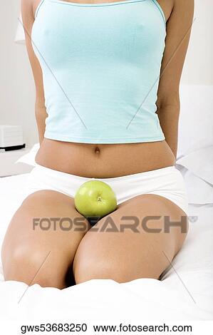 Mid section view of a woman with a green apple on her lap View Large Photo Image Stock Image - Mid section view of a woman with a green apple on her lap. Fotosearch