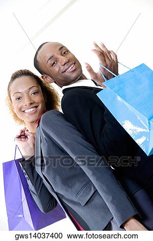 Portrait of a businessman and a businesswoman holding shopping bags View Large Photo Image Stock Image - Portrait of a businessman and a businesswoman holding shopping bags. Fotosearch