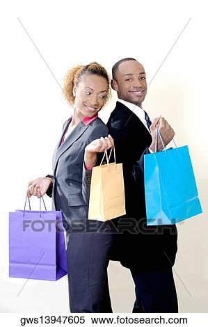 Portrait of a businessman and a businesswoman holding shopping bags View Large Photo Image Stock Photography - Portrait of a businessman and a businesswoman holding shopping bags. Fotosearch