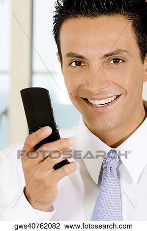 Stock Image - Portrait of a businessman holding a mobile phone. Fotosearch