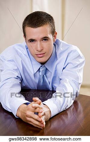 Portrait of a businessman leaning on a table View Large Photo Image Stock Photo - Portrait of a businessman leaning on a table. Fotosearch