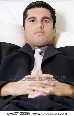Portrait of a businessman resting on a couch View Large Photo Image Stock Photograph - Portrait of a businessman resting on a couch. Fotosearch