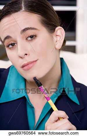 Portrait of a businesswoman holding a pen View Large Photo Image Picture - Portrait of a businesswoman holding a pen. Fotosearch