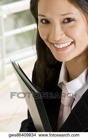 Picture - Portrait of a businesswoman holding a file. Fotosearch