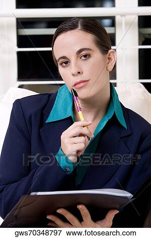 Portrait of a businesswoman holding a pen View Large Photo Image Stock Photo - Portrait of a businesswoman holding a pen. Fotosearch