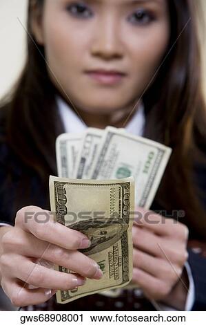 Portrait of a businesswoman holding one hundred dollar bills View Large Photo Image Stock Image - Portrait of a businesswoman holding one hundred dollar bills. Fotosearch