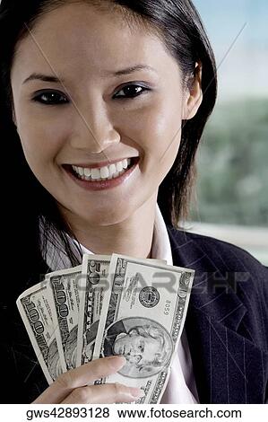 Portrait of a businesswoman holding American paper currency View Large Photo Image Stock Photo - Portrait of a businesswoman holding American paper currency. Fotosearch