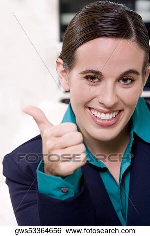 Portrait of a businesswoman making a thumbs up sign View Large Photo Image Stock Photograph - Portrait of a businesswoman making a thumbs up sign. Fotosearch