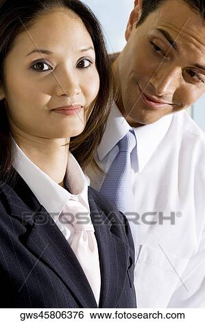 Portrait of a businesswoman with a businessman standing behind her View Large Photo Image Stock Photograph - Portrait of a businesswoman with a businessman standing behind her. Fotosearch