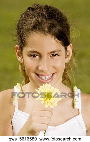 Portrait of a girl holding a flower View Large Photo Image Stock Image - Portrait of a girl holding a flower. Fotosearch