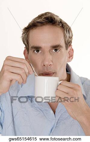 Portrait of a mid adult man blowing into a cup View Large Photo Image Stock Photography - Portrait of a mid adult man blowing into a cup. Fotosearch