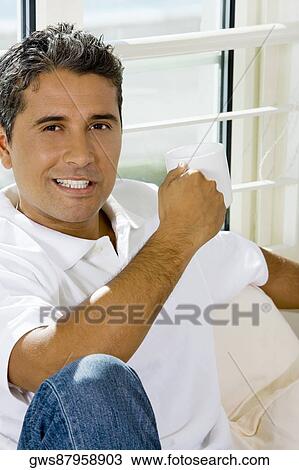 Portrait of a mid adult man holding a cup View Large Photo Image Stock Image - Portrait of a mid adult man holding a cup. Fotosearch