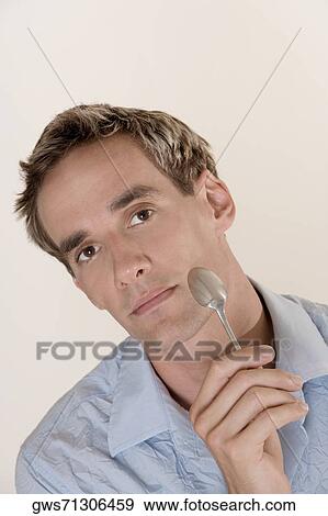 Portrait of a mid adult man holding a spoon View Large Photo Image Stock Photo - Portrait of a mid adult man holding a spoon. Fotosearch