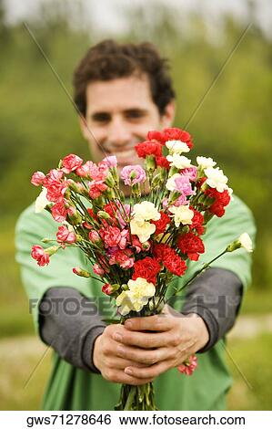 Portrait of a mid adult man holding a bunch of flowers View Large Photo Image Stock Photograph - Portrait of a mid adult man holding a bunch of flowers. Fotosearch