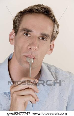 Portrait of a mid adult man licking a teaspoon View Large Photo Image Stock Photo - Portrait of a mid adult man licking a teaspoon. Fotosearch