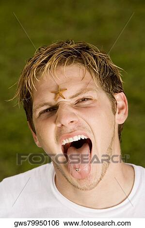 Stock Photograph - Portrait of a young man sticking out his tongue. Fotosearch